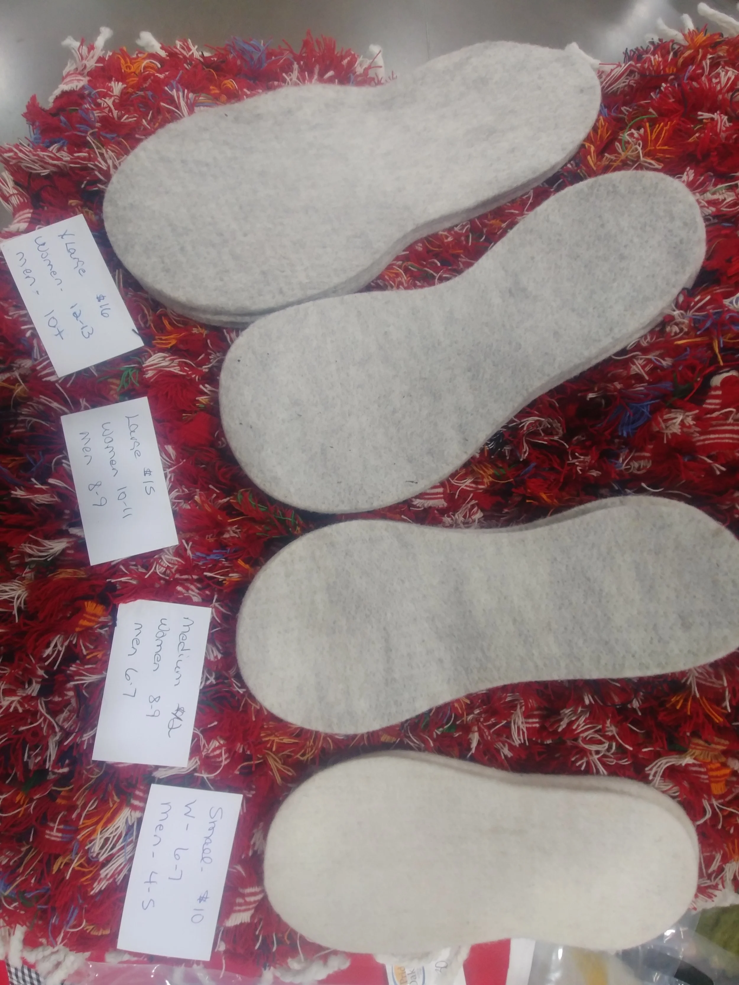 Pairs of white wool insoles laid out for sale