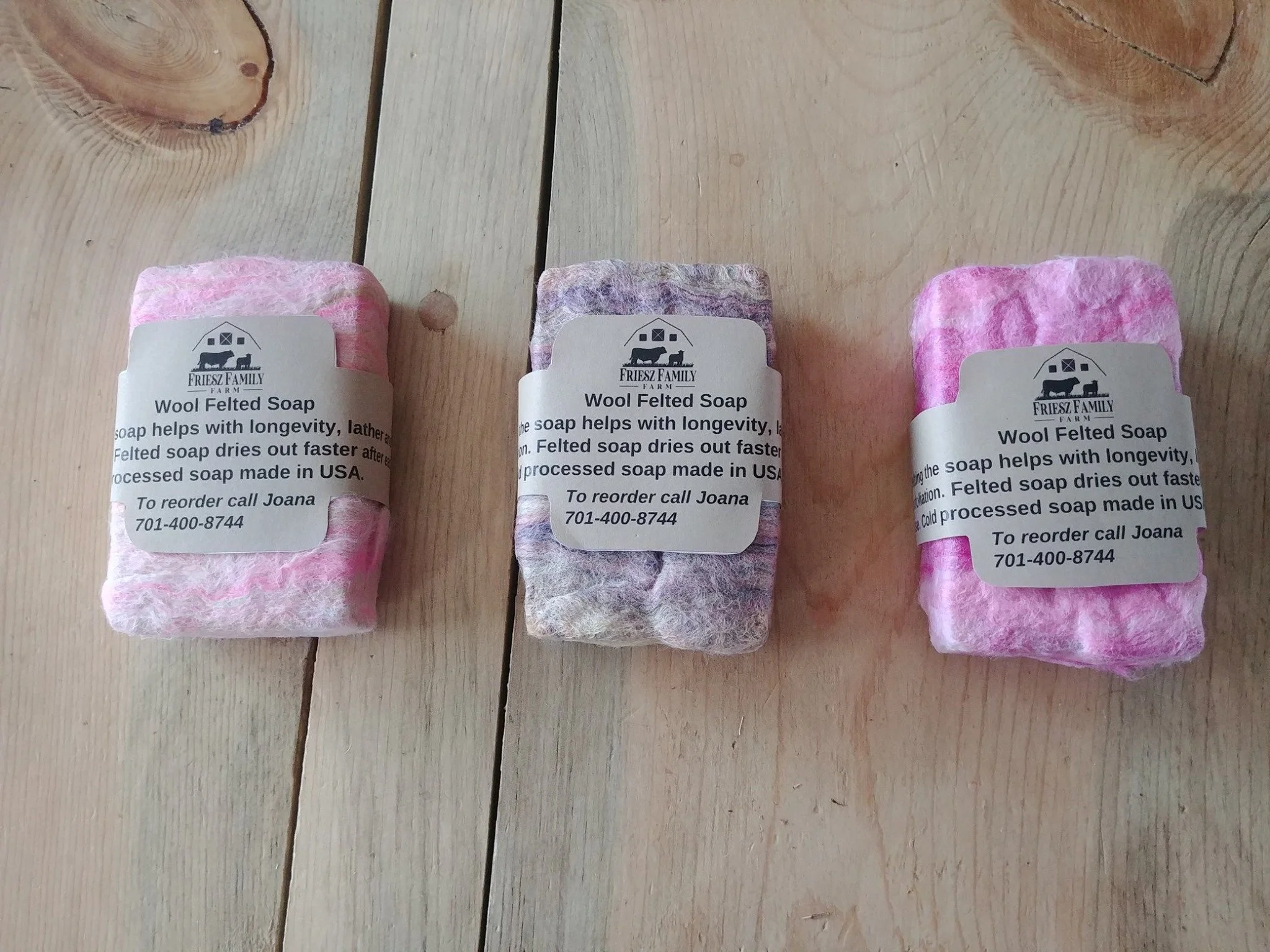 Three wool felted soap bars on a wooden board